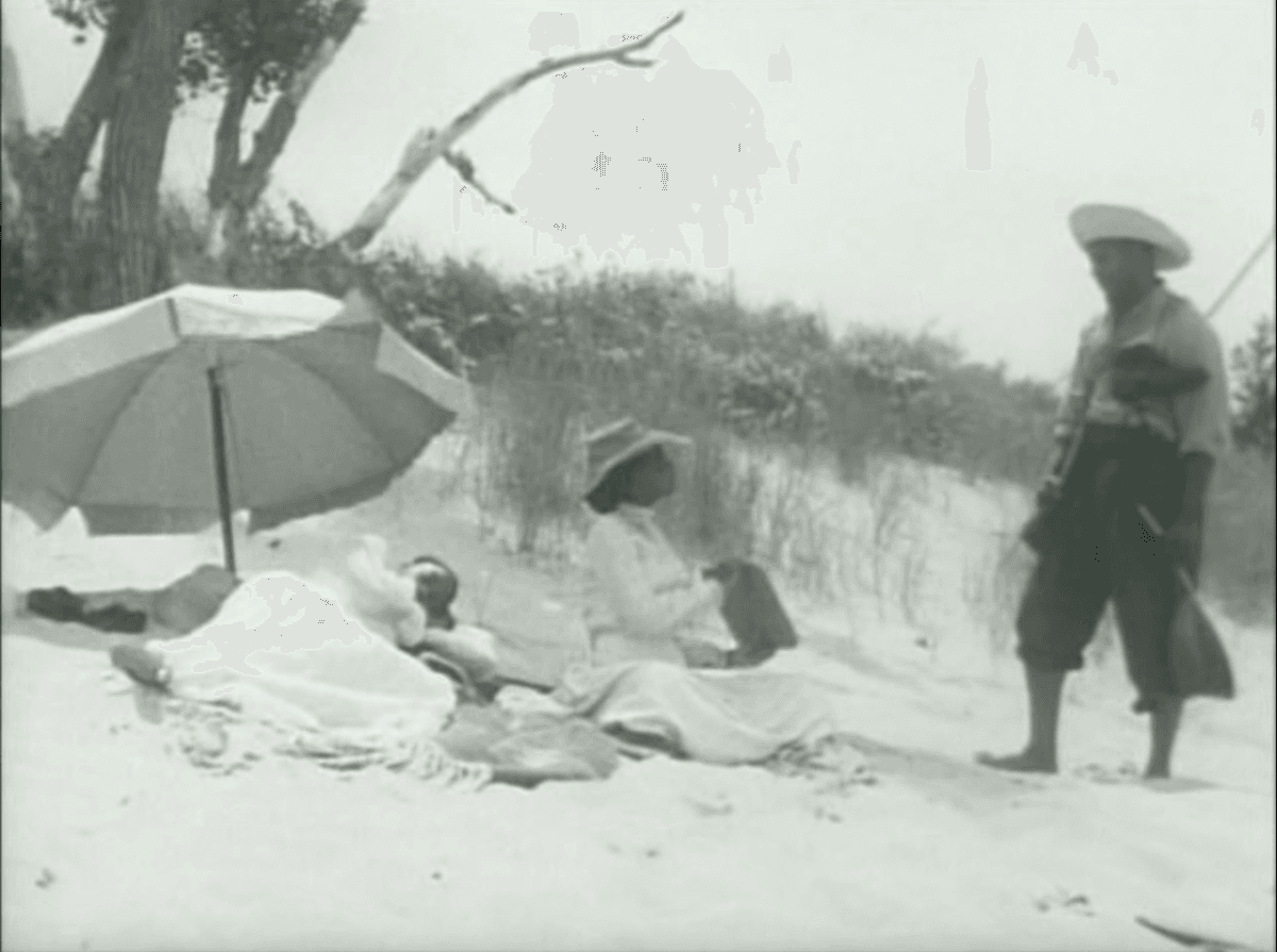 3. Still in the same scene, the woman holds up her block towards the man presumably with words on it and he steps back - regarding it.