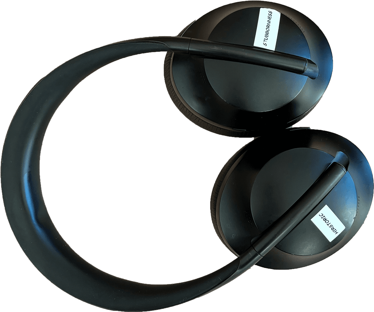 1. The “up” side of Ren’s noise cancelling headphones are shown. On each ear are two printed stickers reading “HIRSTORIC” “STUBBORNNESS”.