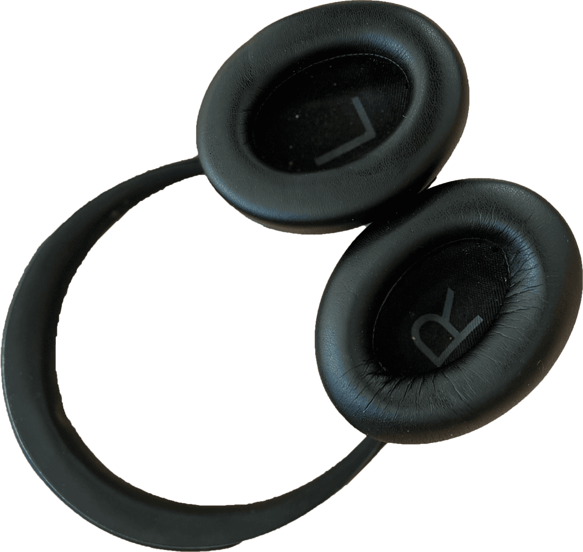 2. The inside of Ren’s Noise Cancelling Headphones are shown, the inner “L” and “Right” are shown face up, they are black and made out of various plush and plastic materials.